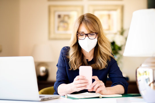 Middle Aged Woman Wearing Face Mask For Prevention While Working From Home