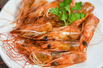 Deep fried crispy shrimp head delicious seasoning spices on plate and wooden table background / cooked shrimps or prawns Seafood shelfish