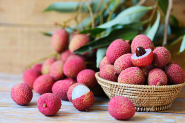 Lychee slice peeled on wooden - Fresh lychee with green leaves harvest in basket from tree tropical fruit summer in Thailand