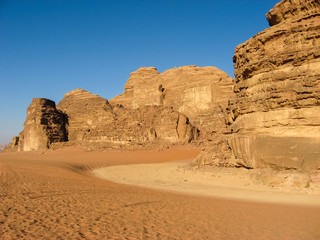 Fototapeta na wymiar Picturesque rocks of Wadi rum in the Jordanian part of the Arabian desert among orange and yellow sand.