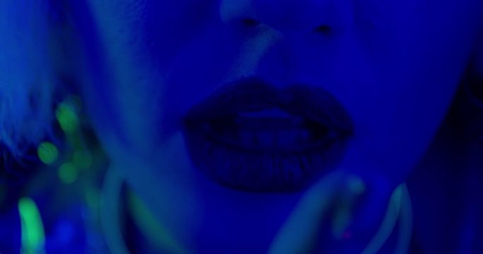 Beautiful young woman with full lips with lipstick in blue light, studio, 4k