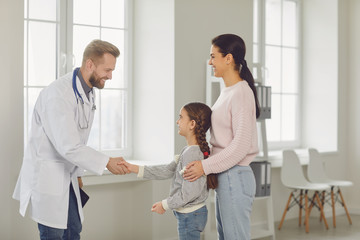 Fototapeta premium Happy family on a visit to the doctor in the office of a doctor.