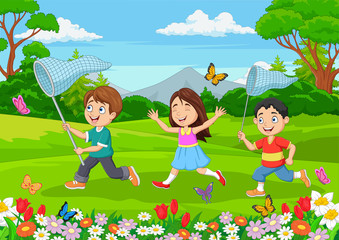 Obraz na płótnie Canvas Children catching a butterfly in the park