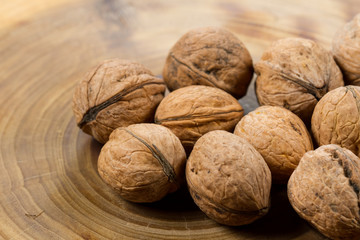 Walnuts close-up on a table from a cut of a poplar trunk, growth rings. Burnt wood texture.