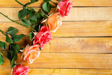 Handmade roses lie on a wooden background. Background layout with free text space.