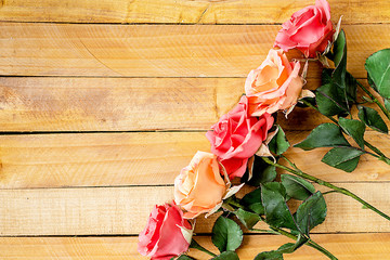 Handmade roses lie on a wooden background. Background layout with free text space.