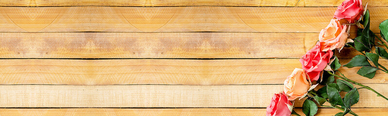 Handmade roses lie on a wooden background. Background layout with free text space.