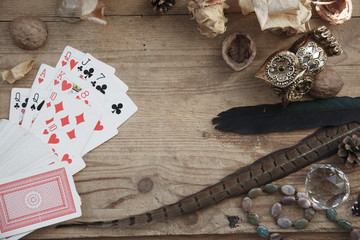 fortune-telling with cards, magic owl, dried roses, nut, birds' feather on wooden background