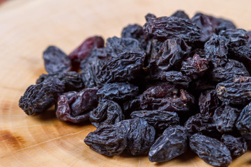 Uzbek blue raisins closeup on a wooden table. Baking ingredients. Healthly food.