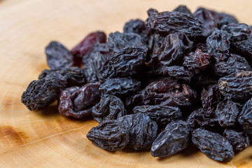 Uzbek blue raisins closeup on a wooden table. Baking ingredients. Healthly food.