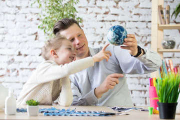 Dad and daughter create a model of planet Earth.