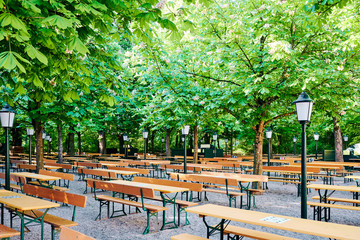 Schöner bayerischer Biergarten mit Bierbänken und Kastanienbäumen in München Öktoberfest