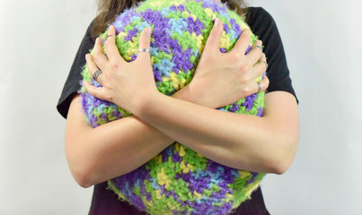 female hands hug a knitted pillow