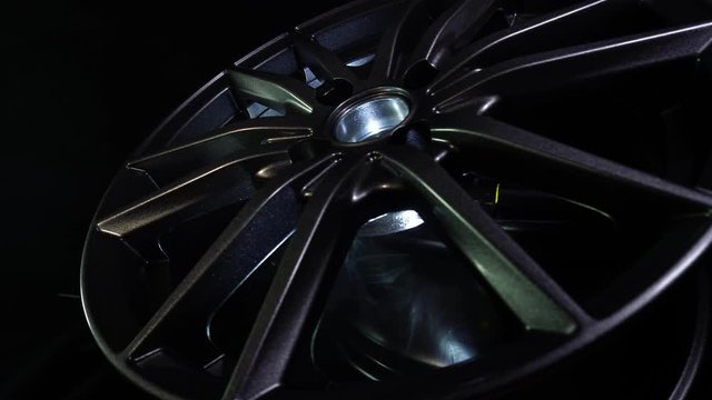 Modern automotive alloy wheel made of aluminum on a black background, industry. Designer fashion wheels for car, mechanic, copy space