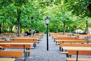 Schöner bayerischer Biergarten mit Bierbänken und Kastanienbäumen in München Oktoberfest