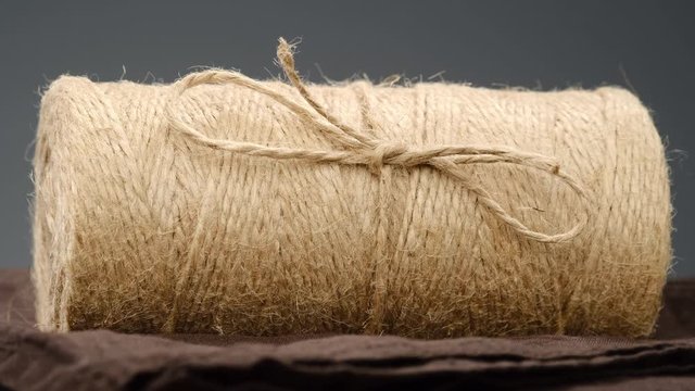 On rotating table is flax hemp rope closeup. jute. grey background