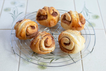 自宅でパン作り　シナモンロール　焼きたてのシナモンロールをケーキクーラーの上に並べる