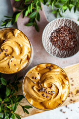 Cold dalgona coffee. Korean trend drink. Drink with cold milk and coffee cream foam in glasses, top view.