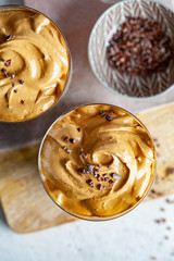 Cold dalgona coffee. Korean drink with cold milk and coffee cream foam in glasses, top view, copy space.