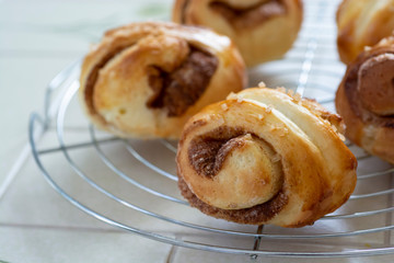 自宅でパン作り　シナモンロール　焼きたてのシナモンロールをケーキクーラーの上に並べる