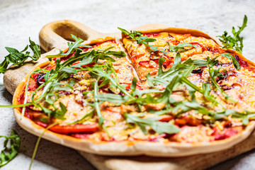 Vegan homemade pizza with tomato sauce, pepper, vegan cheese and arugula. Healthy vegan food concept.