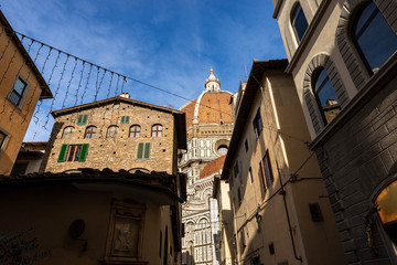 Fototapeta na wymiar Florence Cathedral (Duomo di Firenze, Santa Maria del Fiore) with the famous dome by the architect Filippo Brunelleschi photographed from the narrow streets of the city