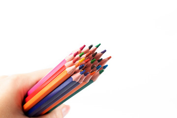 Color pencils in hand isolated on white background. Creative background, copy space.