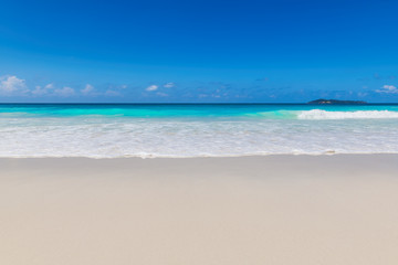Fototapeta na wymiar Beautiful ocean wave on clean sandy beach. Summer background, beach with turquoise tropical sea water.