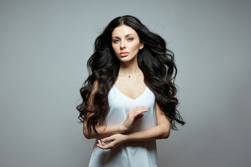 Naklejka premium Sexy fashion woman with long hair, curly strong hair of a brunette girl. Natural cosmetics for hair care, strong roots