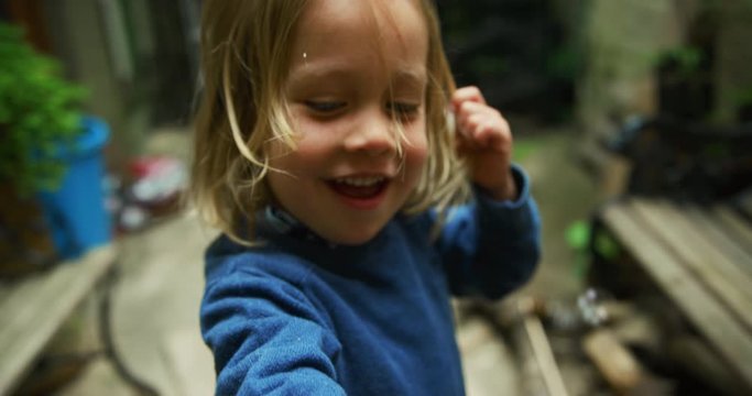 Preschooler showing bubbles on his hand in backyard