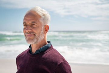 Satisfied senior man thinking at beach