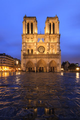 Fototapeta na wymiar Beautiful cityscape view of the Notre-Dame Cathedral in Paris, France, on a rainy spring evening with reflection in the blue hour