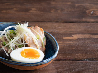 半熟卵とネギの乗ったチャーシューが入ったお皿。