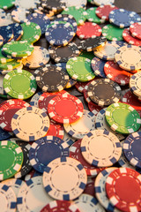 Gambling chips on dark wooden desk.