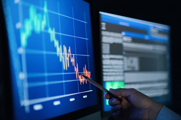 Unrecognizable businessman with computer at desk, working late. Financial crisis concept.