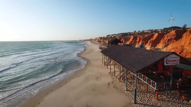 Aerial view backward of golden hour by the beach at Brazil's northeast canoa quebrada, cear&aacute;