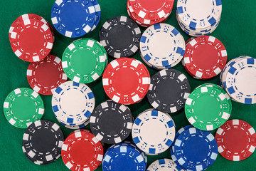 Colorful casino chips on green felt table close up. Gambling concept. Playing poker and other gambling games