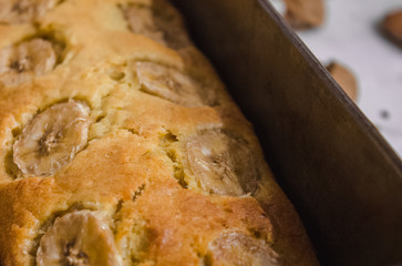 Homemade banana bread peel in baking tray ready to serve on breakfast. Top view. Close up