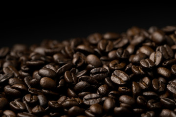 Pile of roasted coffee beans splash on the black background