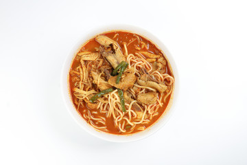 Malaysian curry yellow mee noodle with roasted chicken slice in white bowl on white background