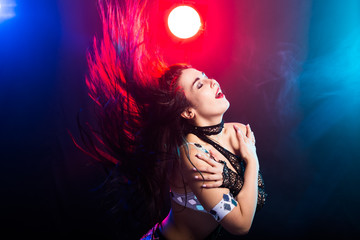 Naklejka premium Girl dancing belly dance, fusion or tribal. A woman in a beautiful costume demonstrates charming and gentle movements in the dance.