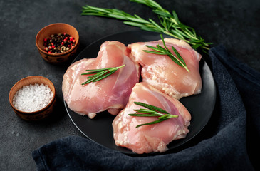 Raw skinless chicken thighs on stone background