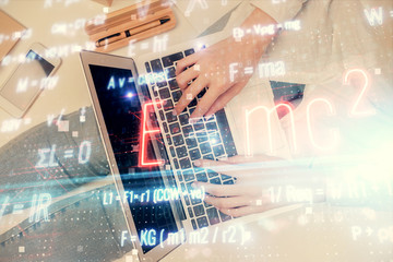 Double exposure of woman hands working on computer and formula hologram drawing. Top View. Science concept.