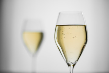 White wine in a beautiful glass on grey background, soft focus
