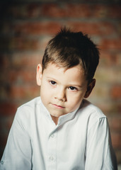 offended child on a brick background closeup portrait