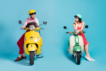 Portrait of his he her she nice attractive cheerful cheery couple sitting on moped wearing retro festal look communicating acquaintance isolated on bright vivid shine vibrant blue color background