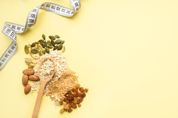 Two spoons of different sizes are filled with oatmeal and golden flax, raisins, almonds, pumpkin seeds. Healthy breakfast, proper nutrition, diet.