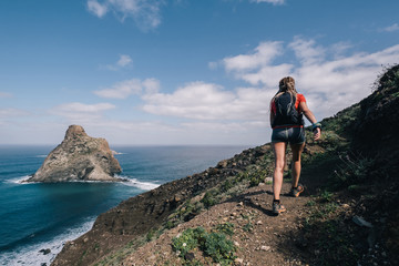 Fototapeta premium Woman runs cross country on a path in mountain path at Canary Island. Ocean view