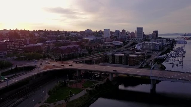 Downtown Skyline And Cars Travelling At 509-BridgeOver Thea Foss Waterway At Dawn In Tacoma, Washinton.-aerial drone shot