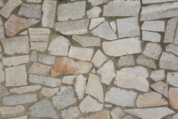 Natural texture and background. Wall of pieces of chipped stone granite